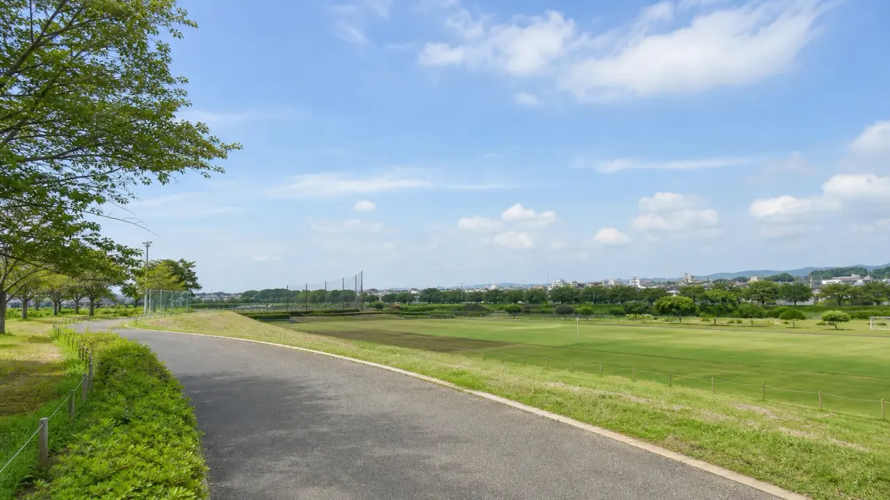 広い芝生と外周の遊歩道、青空が広がる綾瀬スポーツ公園のカバー画像