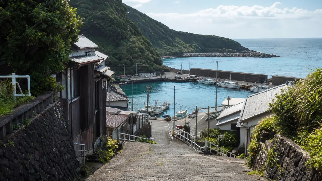 伊豆大島の波浮港をイメージした、坂道の先に静かな入江が見えるカバー画像