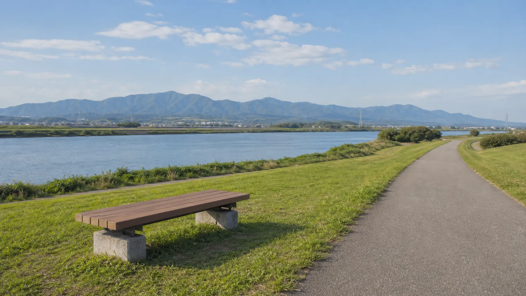 川沿いの芝生とベンチで短く休むイメージ