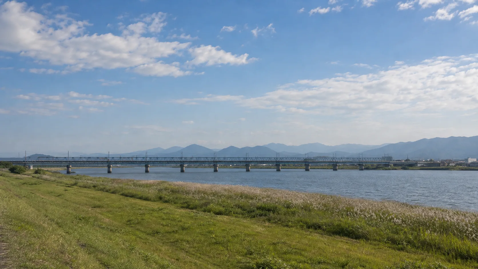 川越しに鉄橋と山並みを眺めるイメージ