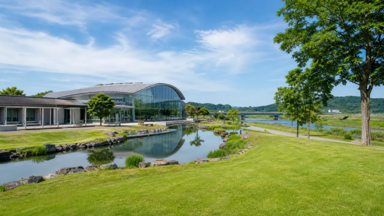 那珂川の広い公園と淡水魚水族館を思わせる水辺の建物、芝生、青空