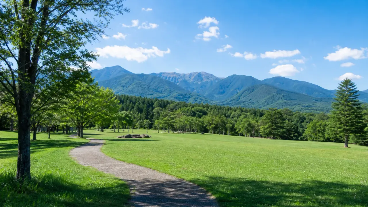 木祖村のやぶはら高原こだまの森を思わせる、芝生広場と山並みのカバー画像