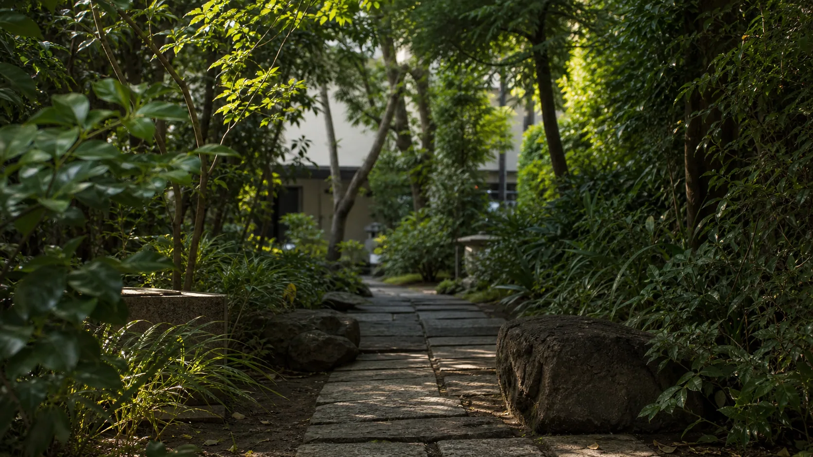 木陰の石畳と植栽が続く静かな寄り道のイメージ